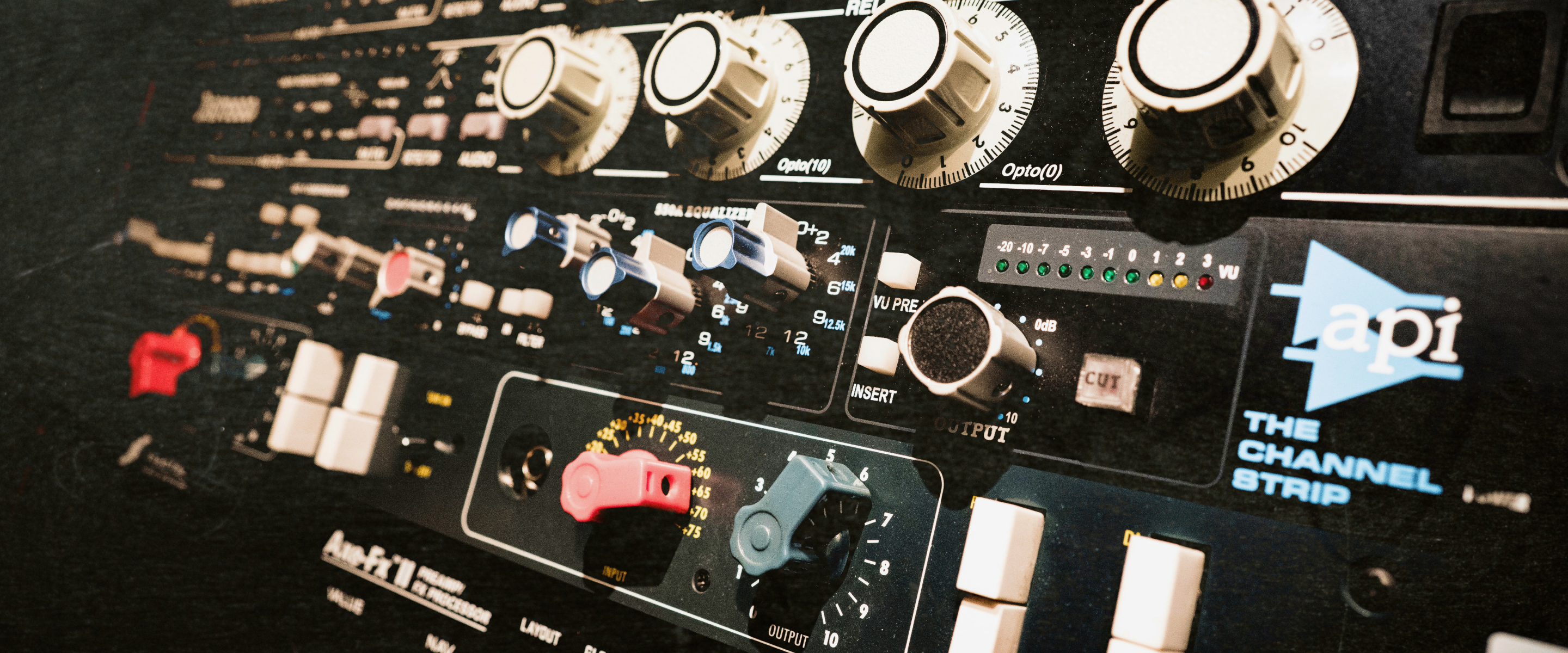 Close-up of various vintage analog gear, including a channel strip, equalizer, and compressor